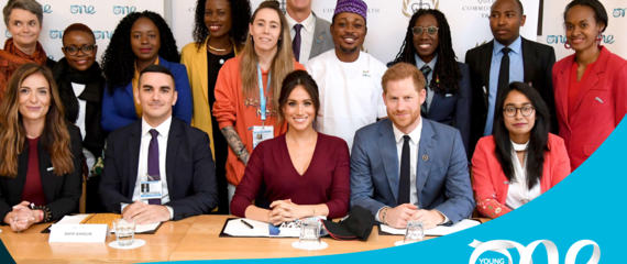 Meghan and Harry at a table surrounded by One Young World Ambassadors